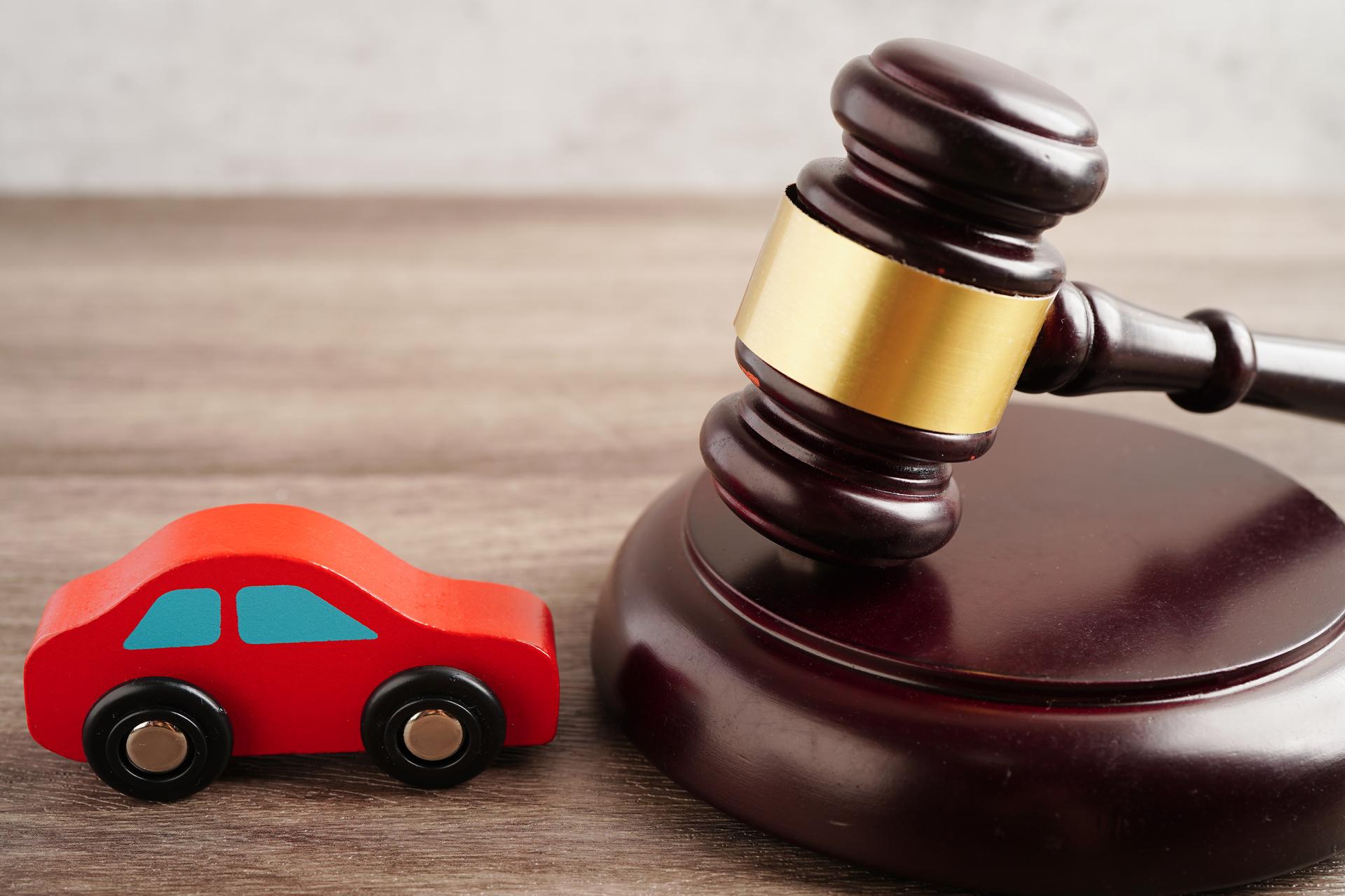 Car accident lawsuit and insurance, Judge hammer with car model.